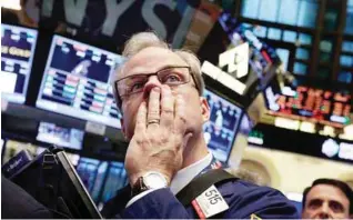  ?? —AP ?? NEW YORK: Trader David O’Day works on the floor of the New York Stock Exchange at the close of trading.