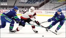  ?? Canadian Press photo ?? Vancouver Canucks centre Brandon Sutter (20) and Canucks left wing Tanner Pearson (70) check Ottawa Senators right wing Drake Batherson during first period NHL action in Vancouver, Wednesday.