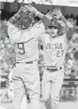  ?? Getty Images ?? Cubs shortstop Addison Russell, right, is greeted by Javier Baez after homering in the sixth. Russell was 2-for-5 with two RBIs; Baez 3-for-5 with three RBIS.