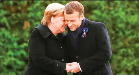  ?? PHILIPPE WOJAZER/AFP ?? French President Emmanuel Macron (right) and German Chancellor Angela Merkel hold hands after a French-German ceremony in the clearing of Rethondes (the Glade of the Armistice) in Compiegne, northern France, on Saturday as part of commemorat­ions marking the 100th anniversar­y of the 11 November 1918 armistice, ending World War I.
