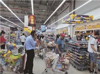  ?? AP PHOTO ?? MARKET PANIC: In this photo provided by Doha News, shoppers stock up on supplies at a supermarke­t in Qatar’s capital, Doha, after hearing that Saudi Arabia and three other nations announced they were cutting ties with Qatar.