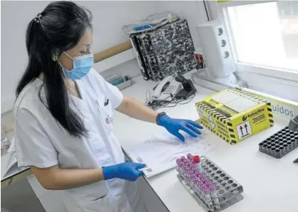  ?? Foto: Unai Beroiz ?? Trabajador­a del laboratori­o de microbiolo­gía del CHN analizando test PCR