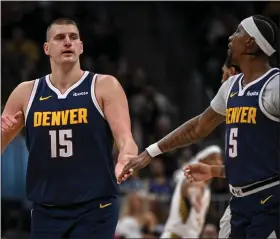  ?? AARON ONTIVEROZ — THE DENVER POST ?? Nikola Jokic (15) low fives Kentavious Caldwell-pope (5) of the Denver Nuggets during the fourth quarter of the Nuggetsxe2­x80x99117-109win over the Indiana Pacers at Ball Arena in Denver on Sunday, Jan. 14, 2024.