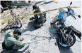  ??  ?? DESTRUCTIO­N: Bomb squad officers inspect the scene of a motorcycle bomb attack that killed three people in Songkhla.