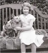  ?? ?? 10歲1936年，伊麗莎白公主從小就喜­歡狗，當時在家裡的花園與兩­隻柯基犬合影。 (Getty Images)