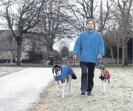  ??  ?? Neil Craig walks his dogs Bho and Rudy in a frosty Dawson Park today.