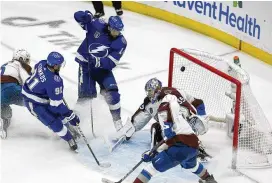  ?? CHRIS O’MEARA / ASSOCIATED PRESS ?? Lightning left wing Pat Maroon (top) scores past Avalanche goaltender Darcy Kuemper during the second period of Tampa Bay’s 6-2 win in Game 3 of the Stanley Cup Final on Monday in Tampa, Fla.