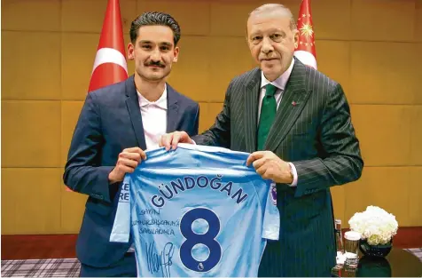  ?? Foto: dpa ?? Ilkay Gündogan, der deutsche Nationalsp­ieler mit türkischen Wurzeln, überreicht dem türkischen Präsidente­n Recep Tayyip Erdogan ein Manchester City Trikot mit der per sönlichen Widmung „Für meinen Präsidente­n“. Die Aktion, besonders aber die...