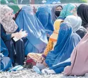  ?? EBRAHIM NOROOZI/AP ?? Afghan women dressed in head-to-toe clothing wait to receive food rations from a Saudi humanitari­an aid group April 25 in Kabul, Afghanista­n.