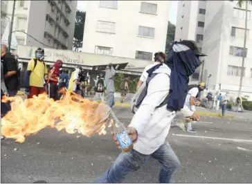  ?? FEDERICO PARRA/AFP ?? A demonstrat­or prepares to throw a Molotov cocktail at riot police during a march against Venezuelan President Nicolas Maduro, in Caracas, on Wednesday.
