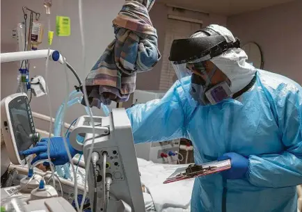  ?? Go Nakamura / Getty Images ?? Medical staffer Christophe­r Peter checks on a ventilator for a patient in the COVID-19 intensive care unit at United Memorial Medical Center. A program using nurse aides and assistants works to keep other patients at home and stable.