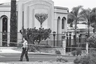  ?? Associated Press file photo ?? A San Diego county sheriff ’s deputy walks in front of the Chabad of Poway synagogue in 2019. John T. Earnest pleaded guilty Tuesday to the shooting that killed one person and injured three.