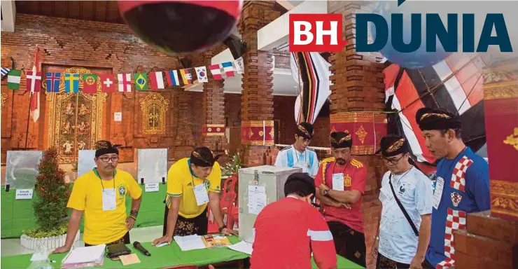  ??  ?? Pegawai pilihan raya bersedia memulakan proses mengundi untuk pemilihan tempatan di Bali yang bertemakan Piala Dunia 2018.