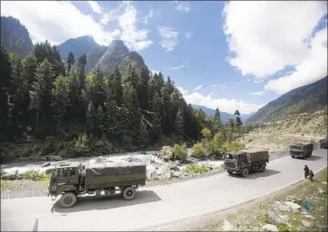  ?? Mukhtar Khan Associated Press ?? AN INDIAN ARMY convoy traverses the highway linking Srinagar and Ladakh in the Indian-held portion of Kashmir. India and China have been locked in a standoff along their disputed Himalayan border since May.