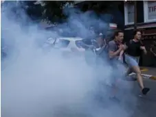  ?? CHRIS MCGRATH/GETTY IMAGES ?? LGBTQ supporters run from tear gas fired by police after attempting to march to Istanbul’s Taksim Square on Sunday.