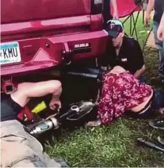  ??  ?? GAMBAR menunjukka­n anggota bomba berusaha mengeluark­an kepala Kaitlyn yang tersangkut di ekzos trak. - Agensi