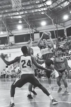  ??  ?? FRANCIS Escandor of the DLSU Green Archers powers his way past three SWU Cobras during their 34th Kadayawan Invitation­al basketball tournament match-up. DLSU won, 65-59. (Photo by Seth delos Reyes DSA/SDD)