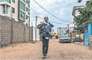  ?? ANDREW ESIEBO PHOTOS THE NEW YORK TIMES ?? Designer Amah Ayivi scours second-hand markets in Togo for gems he mends and resells in Paris.