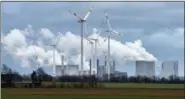  ?? MARTIN MEISSNER — THE ASSOCIATED PRESS ?? Renewable and fossil-fuel energy is produced when wind generators are seen in front of a coal fired power plant near Jackerath, Germany, Friday.