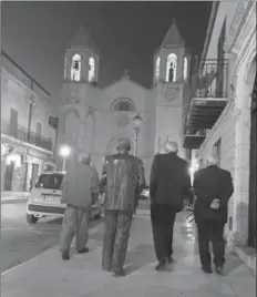  ??  ?? A few citizens of Racalmuto stroll along Via Garibaldi, alongside the statue of the town’s favourite son, late writer Leonardo Sciascia.