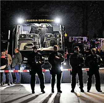  ?? Policisté střeží autobus fotbalové Borussie Dortmund poškozený výbuchem. FOTO ČTK/ AP ?? Místo činu.