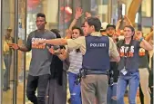  ??  ?? A police officer guides people fleeing the shopping mall after a shooting in Munich, Germany. — AP