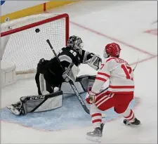  ?? STUART CAHILL — BOSTON HERALD ?? Boston University forward Quinn Hutson scores the OT winning goal against Providence goaltender Philip Svedeback as BU prevailed 2-1 in a Hockey East semifinal.