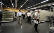  ?? J.T. WAMPLER NWA DEMOCRAT-GAZETTE ?? David Dayringer (from right), chairman of the Washington County Regional Ambulance Authority, Becky Stewart, EMS chief for Central EMS, and Prairie Grove mayor Sonny Hudson join a tour Wednesday of the vacant Wal-Mart Express building