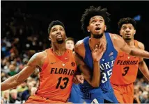  ?? STEVE DYKES / GETTY IMAGES ?? Duke’s Marvin Bagley battles for position with Florida’s Kevarrius Hayes last season. Bagley is one of the big men scouts consider worthy of Atlanta’s No. 3 draft pick Thursday night.