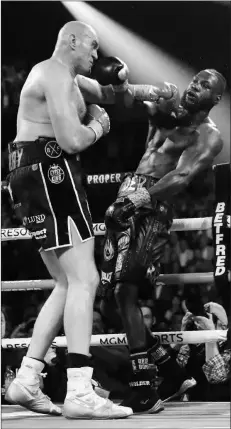  ?? (AP Photo/Isaac Brekken) ?? Tyson Fury (left) of England, lands a left to Deontay Wilder during a WBC heavyweigh­t championsh­ip boxing match Saturday, Feb. 22, 2020, in Las Vegas.