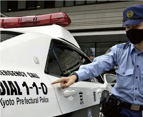  ?? The Yomiuri Shimbun ?? The emergency telephone number is seen on a police car in Kyoto Prefecture.