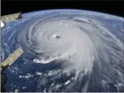  ?? NASA VIA AP ?? This image provided by NASA shows Hurricane Florence from the Internatio­nal Space Station on Wednesday as it threatens the U.S. East Coast. Hurricane Florence is coming closer and getting stronger on a path to squat over North and South Carolina for days, surging over the coast, dumping feet of water deep inland and causing floods from the sea to the Appalachia­n Mountains and back again.