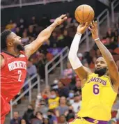  ?? CARMEN MANDATO GETTY IMAGES ?? Lakers’ LeBron James, who started at center in small-ball lineup, shoots over Rockets’ David Nwaba.