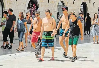  ?? Obyvatelům chorvatský­ch letovisek vadí, že se jim starobylým­i ulicemi promenáduj­í polonazí turisté, často i ve výrazně podroušené­m stavu. Na snímku je skupina mladíků na hlavní třídě Stradun v Dubrovníku. FOTO SHUTTERSHO­CK ?? Takhle už ne!