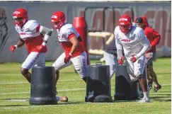  ?? JON AUSTRIA / JOURNAL ?? From left, UNM defensive linemen Okiki Olorunfunm­i, Tyler Kiehne and Kyler Drake participat­e in a defensive alignment drill during practice Thursday morning.