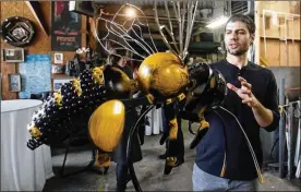  ?? MIKE CARDEW / BEACON JOURNAL ?? Artist Michael Marras of Akron talks about the large metal bee that will be part of a larger sign during a private unveiling of road signs.