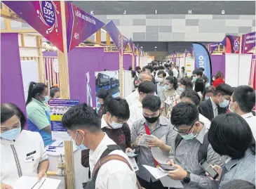  ?? WICHAN CHAROENKIA­TPAKUL ?? People explore employment opportunit­ies at a job expo held last year.