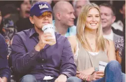  ?? (Lucy Nicholson/Reuters) ?? ACTOR LEONARDO DiCaprio sits courtside with Bar Refaeli at an NBA game in 2010.