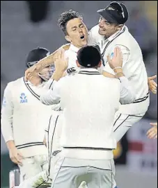  ??  ?? Trent Boult (centre) celebrates after dismissing England captain Joe Root at Eden Park, Auckland on Sunday.