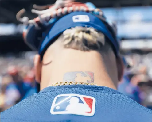  ?? DARRON CUMMINGS/AP ?? In this 2017 photo, the major league baseball logo is shown tattooed on MLB shortstop Javier Baez.