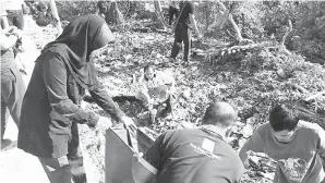  ??  ?? GOTONG royong bersama penduduk kampung.