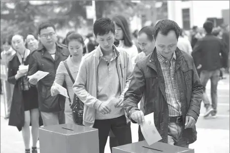  ?? YANG TAO/FOR CHINA DAILY ?? Voters cast their votes for deputies to the local people’s congress in Baokang county, Hubei province, on Oct 10, 2016.