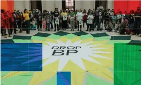  ?? Composite: Guardian Design/Getty Images ?? Protesters stand around a ‘Drop BP’ banner at the British Museum this year. Environmen­tal experts say bumper profits for oil and gas companies underscore what a disastrous year it has been for the global climate.