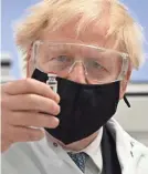  ?? WPA POOL GETTY IMAGES ?? UK Prime Minister Boris Johnson holds a vial of the AstraZenec­a/Oxford University candidate vaccine for coronaviru­s.