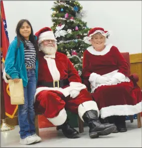  ?? Westside Eagle Observer/MIKE ECKELS ?? Santa and Mrs. Claus pose for a photo with one of the local kids during the Decatur Chamber of Commerce’s talk with Santa event in the community room at Decatur City Hall Friday night.