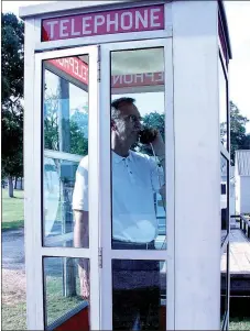  ?? LYNN KUTTER ENTERPRISE-LEADER ?? David Parks, president of PG Telco, makes sure the company’s freestandi­ng phone booth is in working condition after employees repaired the booth in the summer of 2014. A vehicle ran into it and damaged it. The booth has been named to the National Register of Historic Places.