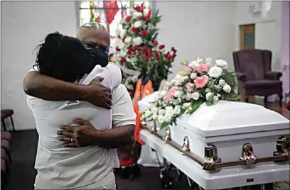  ?? MARCIO JOSE SANCHEZ / AP ?? In this July 21 file photo, Darryl Hutchinson, facing camera, is hugged by a relative during a funeral service for Lydia Nunez, who was Hutchinson’s cousin at the Metropolit­an Baptist Church in Los Angeles. Nunez died from COVID-19. Southern California funeral homes are turning away bereaved families because they’re running out of space for the bodies piling up during an unrelentin­g coronaviru­s surge.