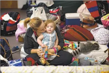  ?? Photograph­s by Gina Ferazzi Los Angeles Times ?? JESSICA SWISHER kisses her 7-month-old daughter Thursday at a church shelter in Chico, Calif. She, her husband and their four daughters are at the shelter after their mobile home park burned to the ground.