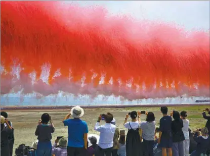  ?? The Day the Cherry Blossoms Were in Full Bloom THE YOMIURI SHIMBUN VIA AP ?? Fireworks are launched on the Yotsukura coast in Iwaki, Fukushima Prefecture, Japan, on June 26 while people pray for peace as part of the art project by Chinese contempora­ry artist Cai Guoqiang.