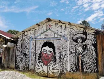  ??  ?? Simboli Murales nel villaggio con accanto la figura di Emiliano Zapata. L’evocazione della rivolta indigena contro la dominazion­e è ancora forte nel Paese che confina con il Messico e con la sua regione più zapatista, il Chiapas